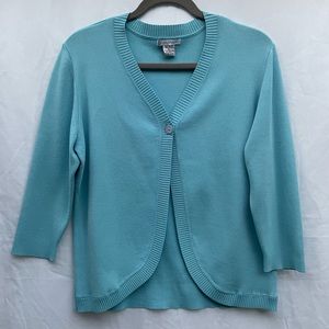 Lauren Hansen cropped blue sweater with one-button closure styled with brooch.